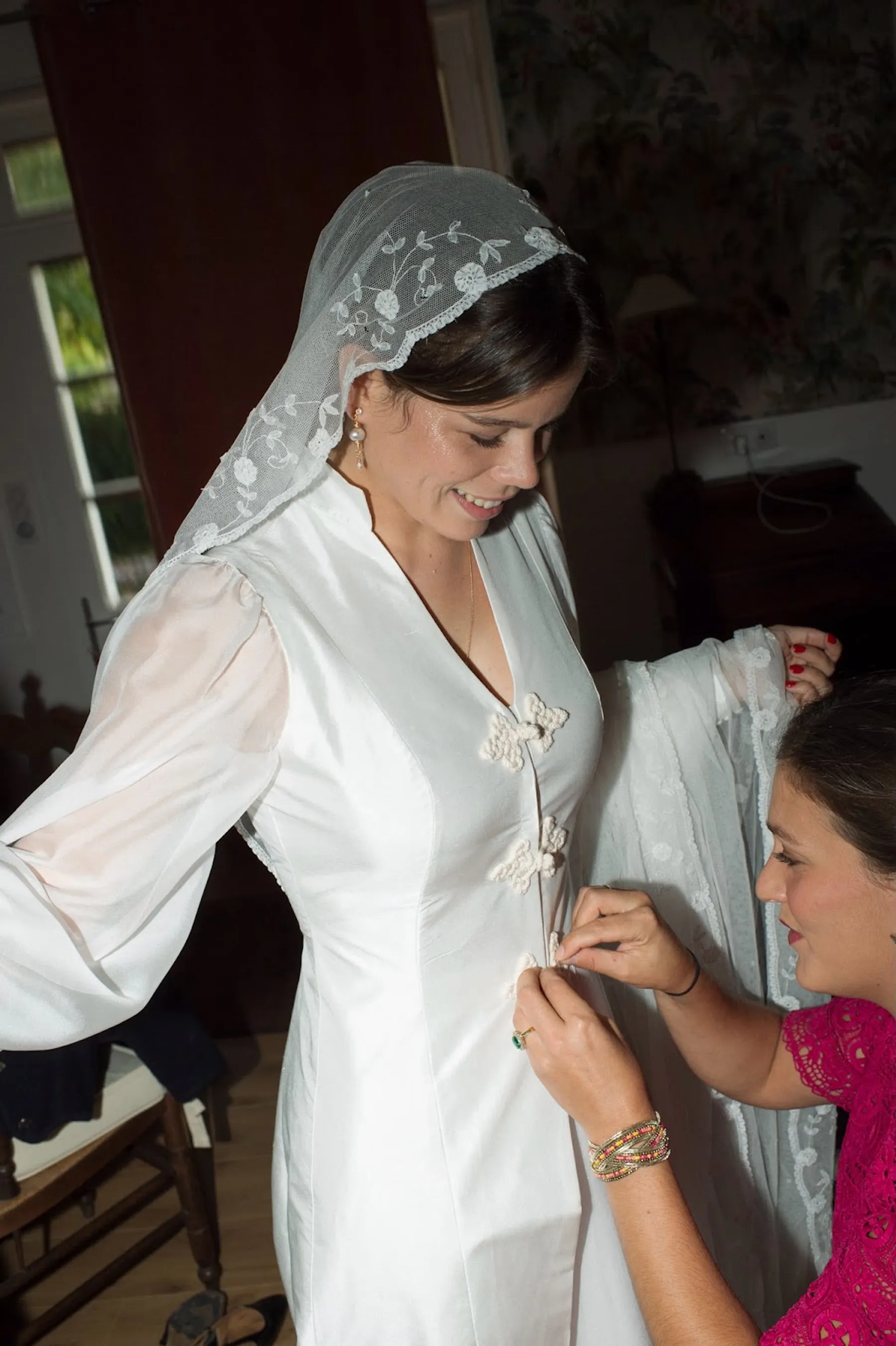 Gros plan sur la fermeture de la robe de mariée d'Eugénie : boutons de passementerie sur le devant, ajustés par une proche